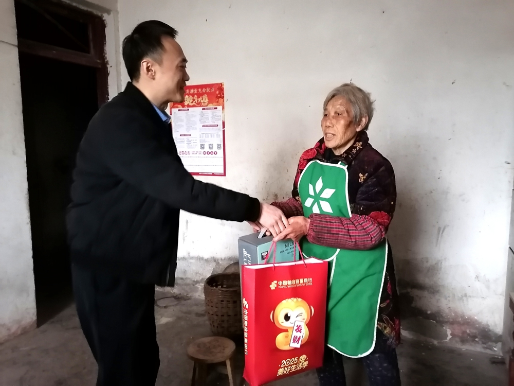 邮储银行泸县支行行长陈强在泸县玉蟾街道小马滩村10社许刘亮家里为其奶奶送上暖心慰问物品